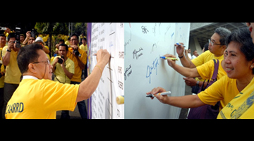 PCAARRD Executive Director Patricio S. Faylon (left photo) signs the “Wall of Commitment” along with employees from PCAARRD and other DOST agencies (right photo). (Photo by Victor V. Oro, S&T Media Service)