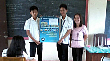 Mrs. Lorna C. Borja of the San Bartolome National High School, San Pablo City, shows the NSTW 2015 poster to her students as she motivates them to join the PCAARRD poster painting contest.